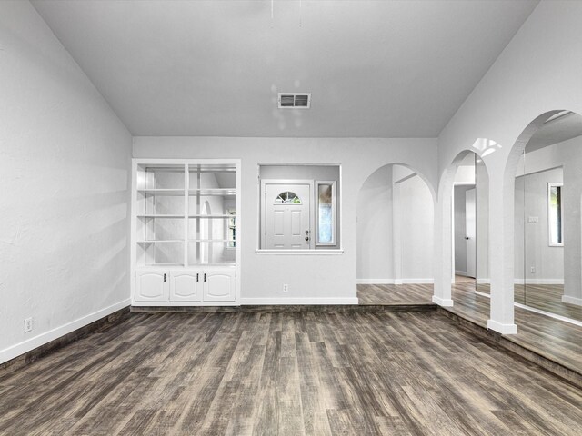 foyer entrance featuring baseboards, visible vents, and dark wood finished floors