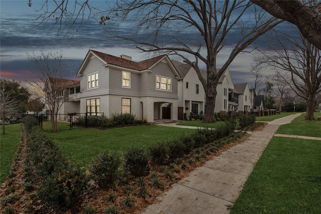 view of front of home featuring a front yard, fence, and stucco siding