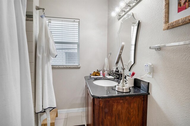 bathroom with tile patterned flooring, vanity, and baseboards