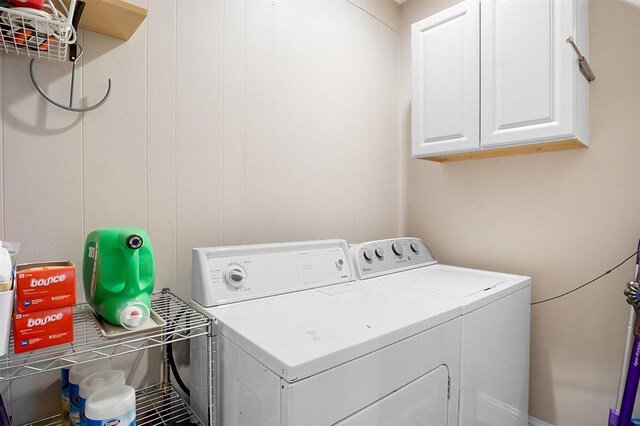 clothes washing area featuring cabinet space and washing machine and clothes dryer