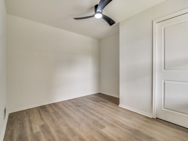 spare room with ceiling fan, baseboards, and light wood-style flooring