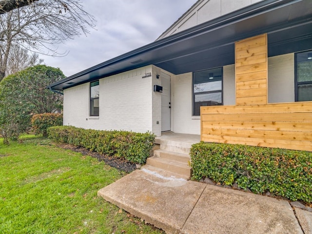 entrance to property with a lawn