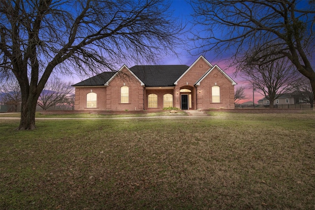 view of front of property with brick siding and a front lawn