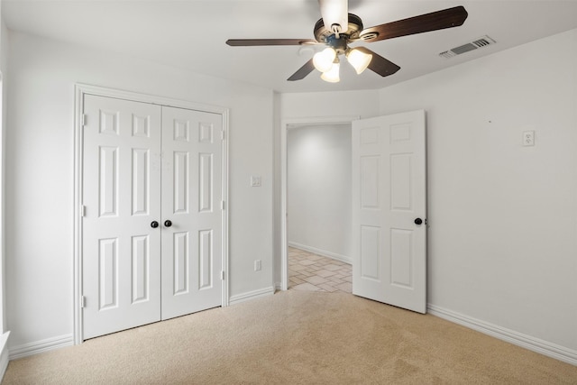 unfurnished bedroom featuring light carpet, baseboards, visible vents, and a closet