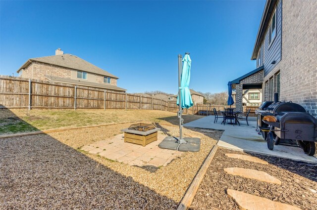 view of yard featuring an outdoor fire pit, a fenced backyard, and a patio