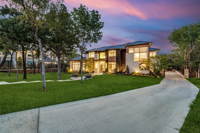 view of front facade featuring metal roof, stone siding, a front lawn, and a standing seam roof