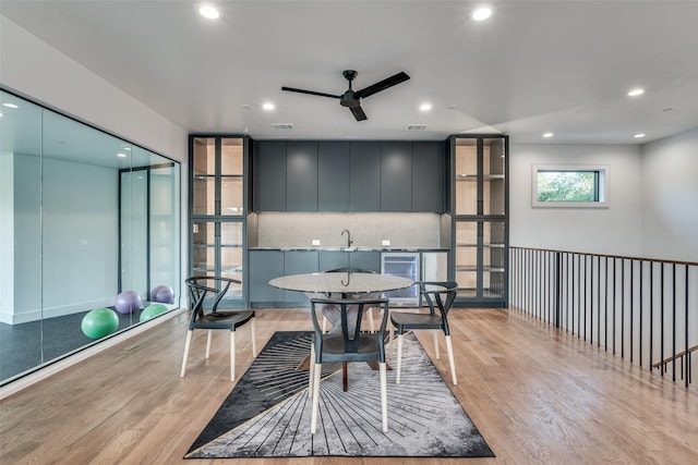 dining area with beverage cooler, light wood-style flooring, and recessed lighting