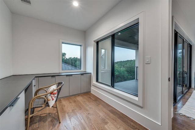 home office with visible vents, built in desk, and light wood-style flooring