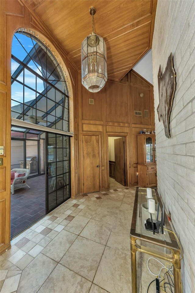 interior space featuring a high ceiling, wood walls, and wood ceiling