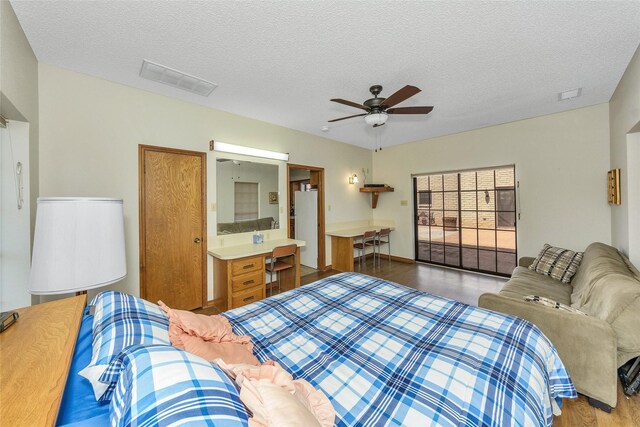 bedroom featuring light wood-style flooring, visible vents, ceiling fan, and a textured ceiling