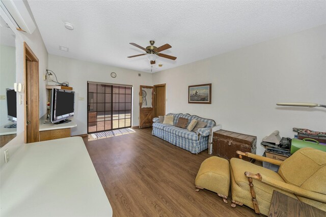 living room with a textured ceiling, a ceiling fan, and dark wood-type flooring