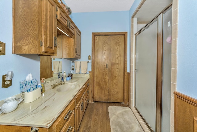 full bathroom with a stall shower, wood finished floors, and vanity