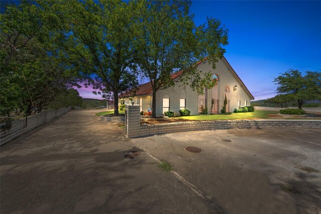 view of property exterior with brick siding and fence