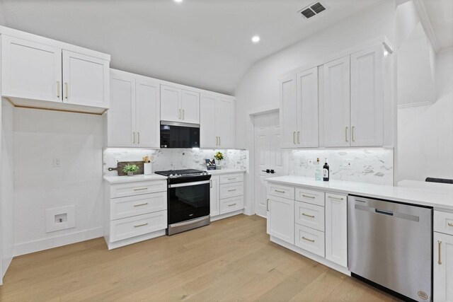 kitchen with stainless steel appliances, light countertops, visible vents, and white cabinetry