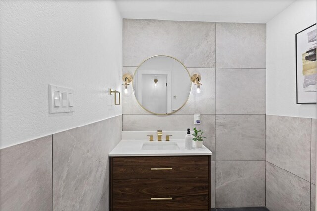 bathroom featuring vanity and tile walls