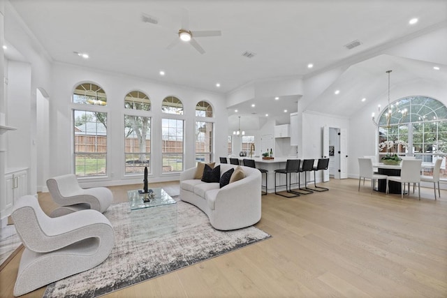 living room with ornamental molding, recessed lighting, visible vents, and light wood-style flooring