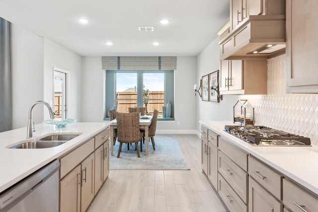 kitchen featuring a sink, stainless steel appliances, light countertops, and visible vents