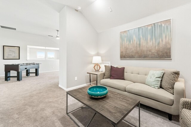 living room featuring lofted ceiling, light carpet, a ceiling fan, visible vents, and baseboards