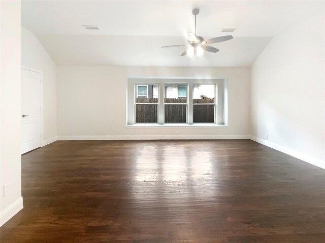 empty room with dark wood-style floors, lofted ceiling, and visible vents