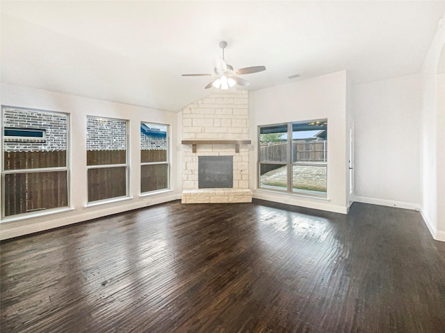 unfurnished living room featuring lofted ceiling, ceiling fan, dark wood-style flooring, a fireplace, and baseboards