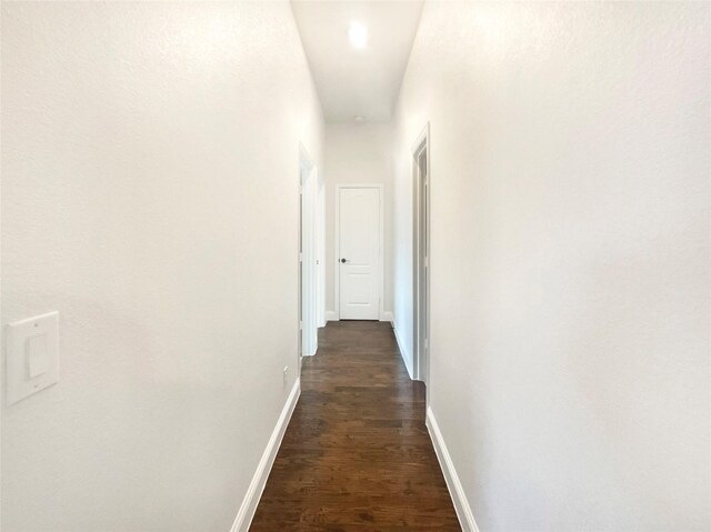 hall with dark wood-style floors and baseboards