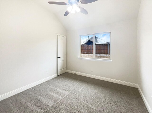 carpeted empty room featuring vaulted ceiling, baseboards, and ceiling fan