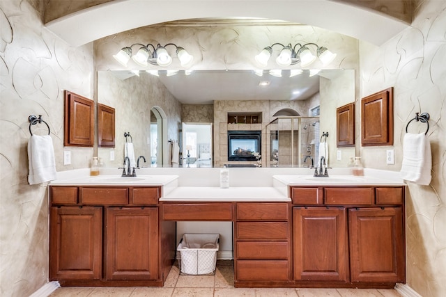 full bath featuring a sink, a shower stall, and double vanity