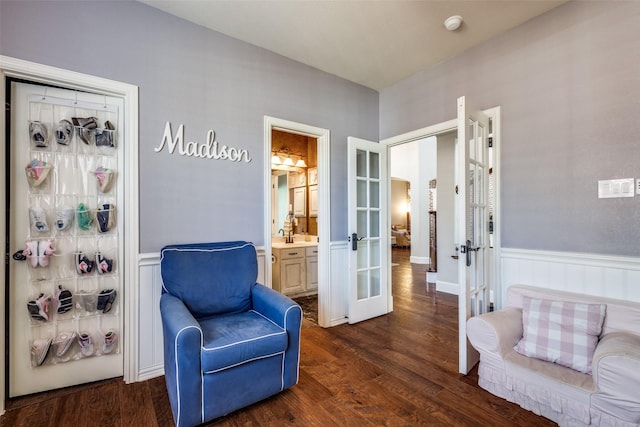 living area featuring french doors, wainscoting, and dark wood finished floors