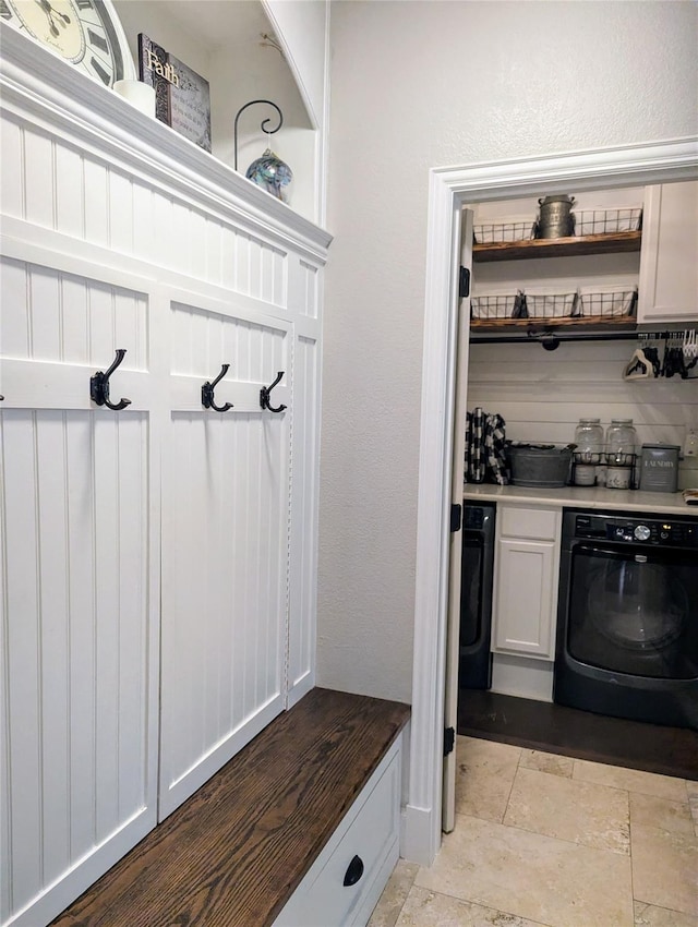 mudroom with washer / dryer and stone tile floors