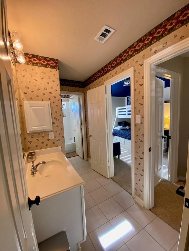 bathroom with wallpapered walls, tile patterned floors, visible vents, and vanity