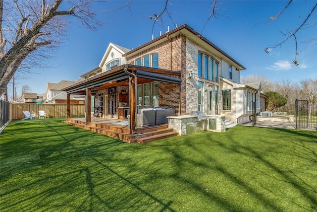 rear view of property with a yard, fence, outdoor lounge area, and brick siding