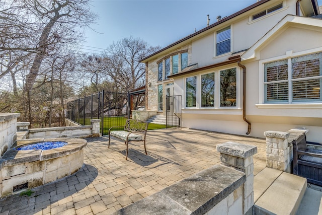 view of patio with an outdoor fire pit and fence