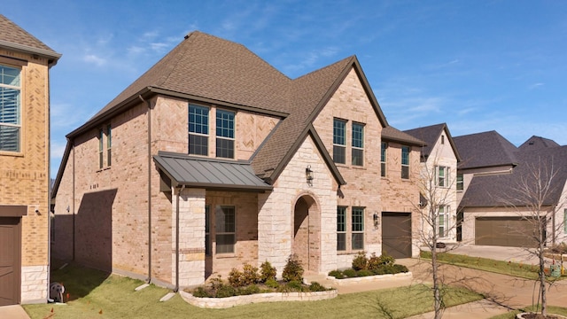 view of front of home with a garage, metal roof, roof with shingles, a standing seam roof, and brick siding