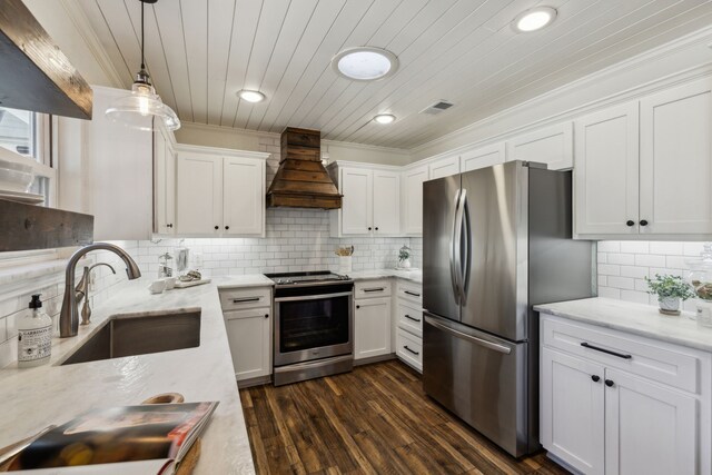 kitchen with visible vents, stainless steel appliances, premium range hood, white cabinetry, and a sink