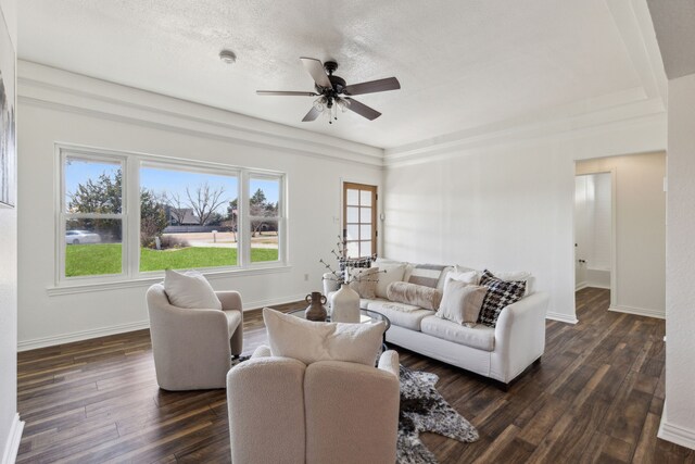 living area with baseboards, ceiling fan, dark wood finished floors, and a healthy amount of sunlight