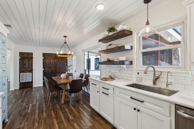 kitchen with decorative light fixtures, open shelves, tasteful backsplash, white cabinetry, and a sink