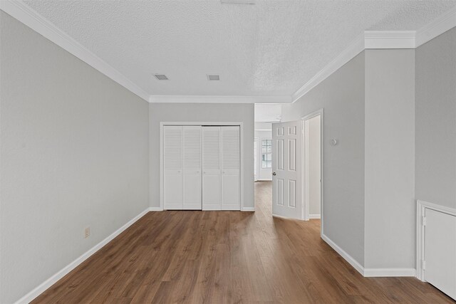 unfurnished bedroom with ornamental molding, a closet, dark wood finished floors, and baseboards