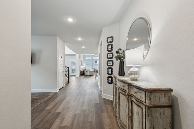 corridor with stairs, baseboards, dark wood-type flooring, and recessed lighting