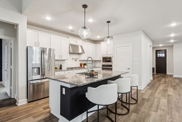 2417 Robin Way, Northlake, TX 76247 - kitchen featuring appliances with stainless steel finishes, under cabinet range hood, light wood-style flooring, backsplash, and white cabinets