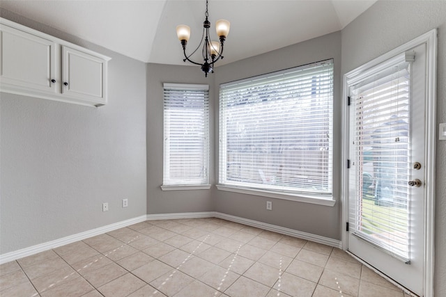 unfurnished dining area with light tile patterned floors, a chandelier, lofted ceiling, and baseboards