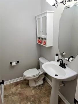 bathroom featuring baseboards and toilet