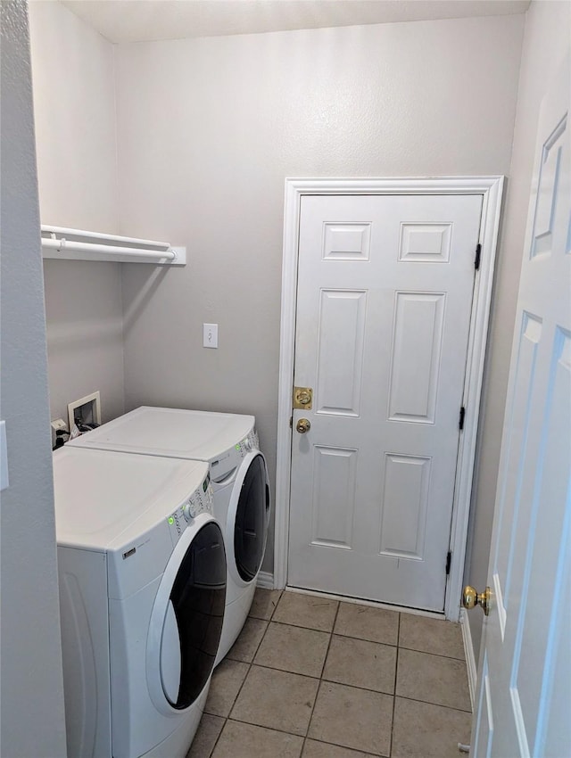 laundry area featuring laundry area, washing machine and clothes dryer, and light tile patterned floors