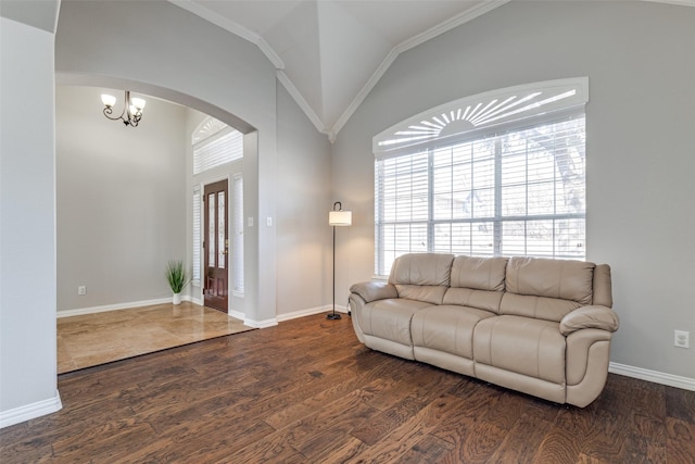 living room with dark wood-style floors, arched walkways, a notable chandelier, vaulted ceiling, and baseboards