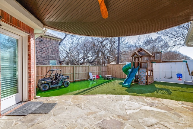 view of play area featuring a patio, a lawn, and a fenced backyard