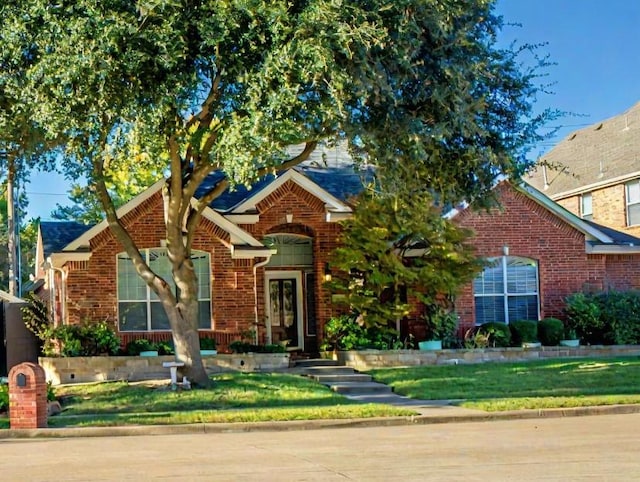 view of front of home featuring a front yard and brick siding