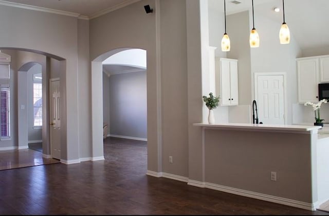 kitchen with dark wood-style floors, white cabinetry, light countertops, and pendant lighting