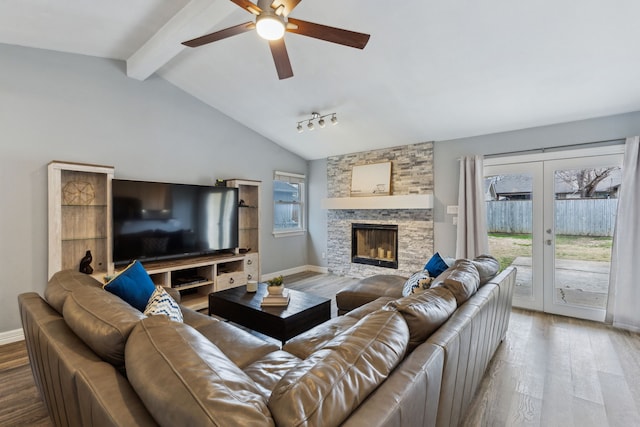 living room with vaulted ceiling with beams, a fireplace, wood finished floors, and baseboards