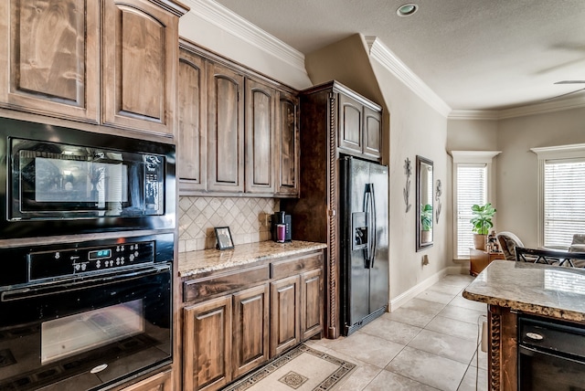 kitchen with light stone counters, crown molding, black appliances, and light tile patterned floors