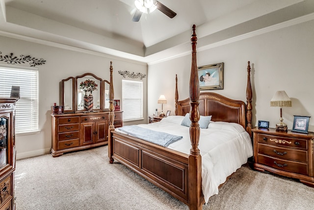 bedroom featuring light carpet, multiple windows, and a tray ceiling