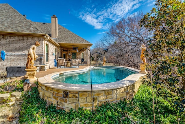 outdoor pool featuring ceiling fan and a patio